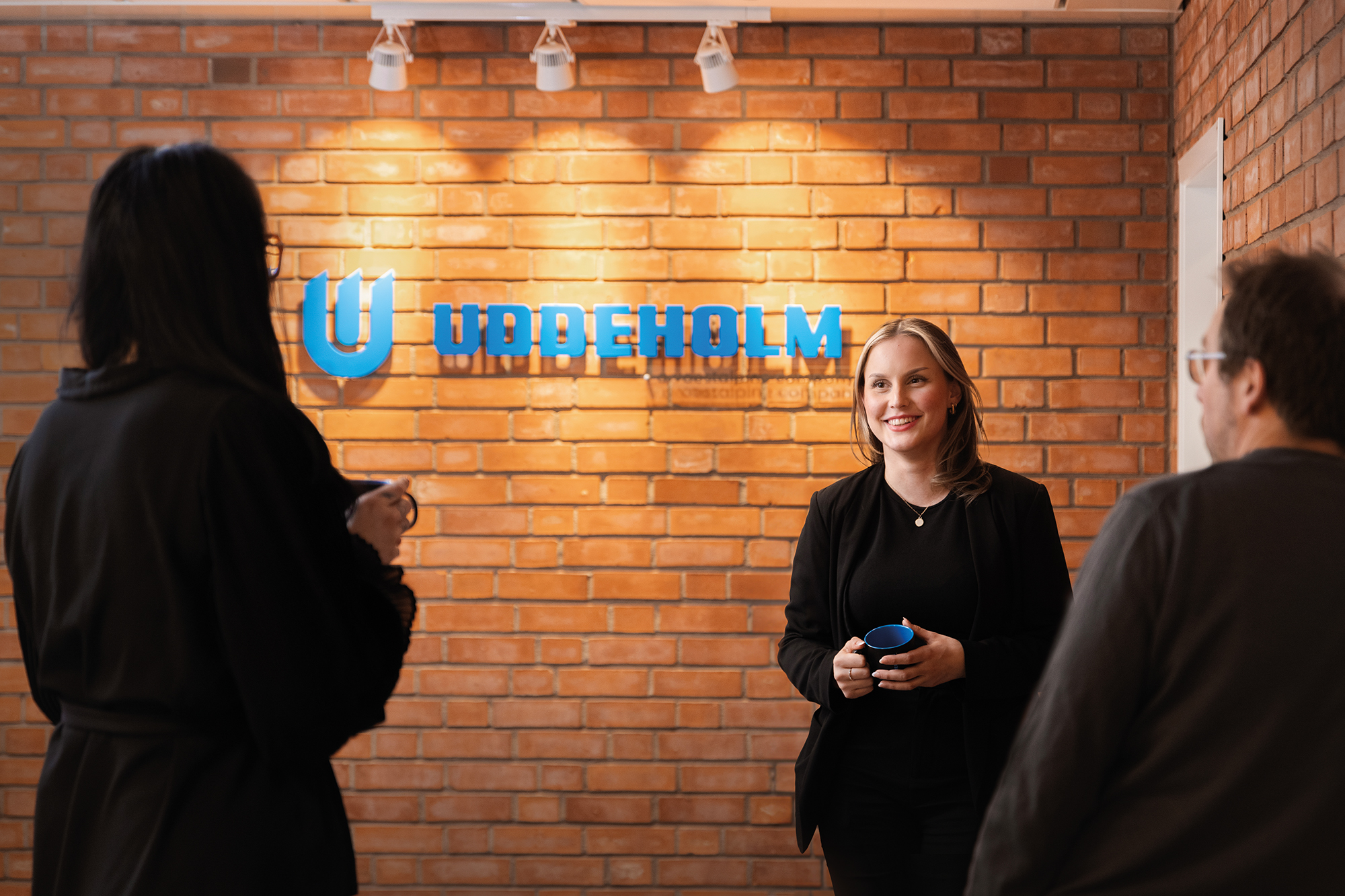 Woman at the office standing next to an Uddeholm sign