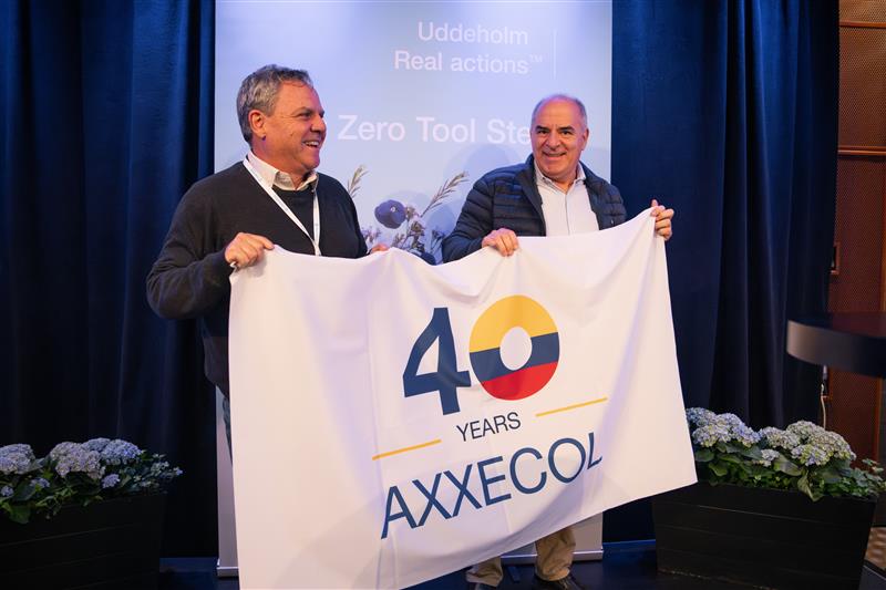 two man with a flag that says 40 years AXXECOL