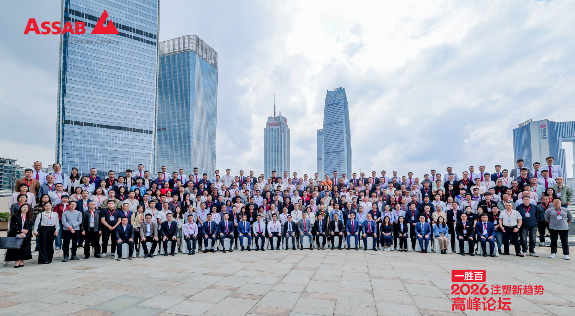 A large group of people in business attire posing for a group photograph in front of tall buildings.